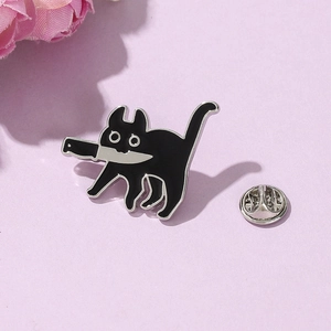 Vue détaillée du pin's émaillé chat noir avec couteau sur fond violet doux