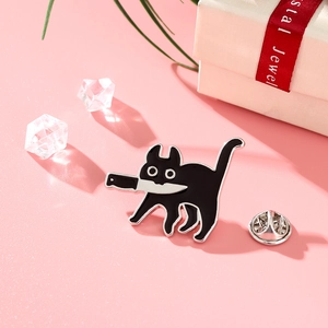 Détail du pin's émaillé chat noir avec couteau sur un fond décoratif rose élégant