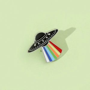 Macro detail of UFO enamel pin with vibrant rainbow beam on high-quality metal finish
