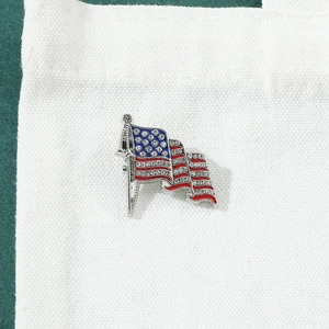 Detailaufnahme der US-Flaggenbrosche mit Strasssteinen auf einer weißen Segeltuchtasche