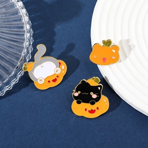 Detail of three creative Halloween enamel pins featuring cute cats and pumpkins