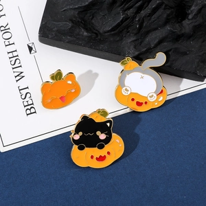 Close-up of three creative Halloween cat enamel pins featuring pumpkins and black kittens