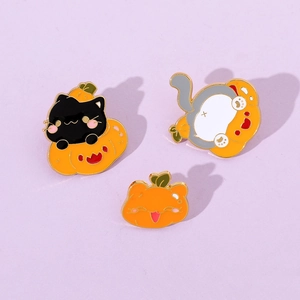 Detailed view of three creative Halloween enamel pins featuring cute cats and pumpkins