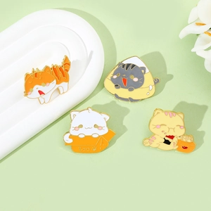 Dettaglio di quattro spillette creative in smalto a forma di gatto con finitura dorata