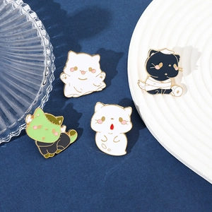 Detailed close-up of ghost and mummy cat enamel pins on blue fabric for Halloween