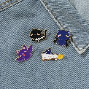 Set of four Halloween enamel cat pins including bat and wizard motifs on denim jacket