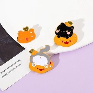 Close-up of three creative Halloween enamel cat and pumpkin pins with gold plating