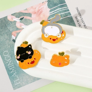 Detailed view of three Halloween enamel pins featuring black cat and pumpkin designs