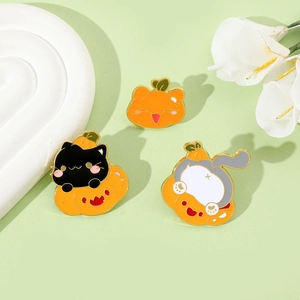 Detailed view of three creative Halloween cat and pumpkin enamel pins on a decorative display