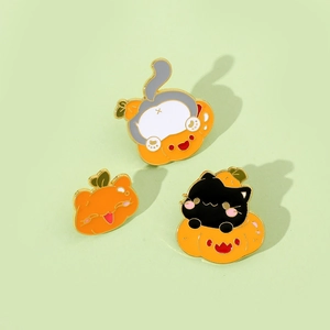 Detail shot of creative Halloween enamel pins featuring cute cats and orange pumpkins