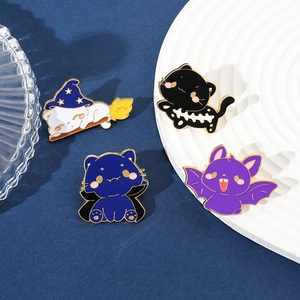 Detailed view of four Halloween enamel pins featuring black cat, white cat, and bat