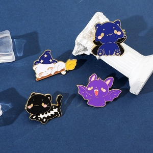 Detailed close-up of four Halloween enamel pins featuring wizard and skeleton cats