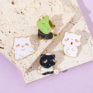 Close-up of four Halloween enamel pins featuring ghost and mummy cats on stone base