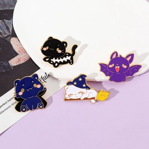 Detailed close-up of a 4-piece set of Halloween cartoon cat enamel pins on a white plate