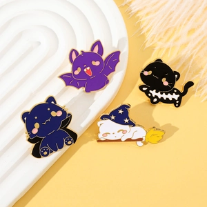 Detailed view of four Halloween cat enamel pins set on a decorative white plate