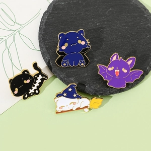 Detailed close-up of four Halloween enamel cat pins with gold plating and vibrant colors