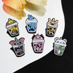 Group of cute animal enamel pins combined with bubble tea cups on a mirror surface