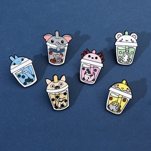 Detail of creative cartoon animal enamel pins featuring bubble tea cup designs in a set