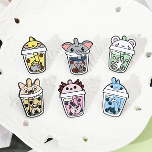 Close-up of animal bubble tea enamel pins on white decorative plate