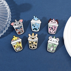 Macro shot of six cute cartoon animal milk tea enamel pins on blue textured surface