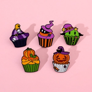 Detailed view of Halloween cupcake enamel pins featuring skull, pumpkin, and wizard hat designs