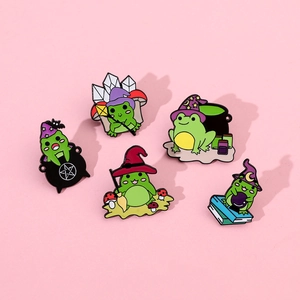 Detailed flat lay of five magical green frog enamel pins with wizard hats and brooms