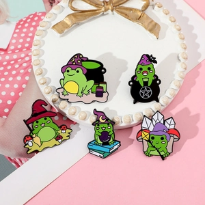 Detailed set of five green magic frog enamel pins displayed on a white tray
