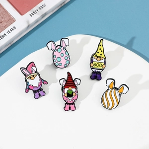 Détails de broches émaillées gnomes et œufs de Pâques colorés sur plateau blanc