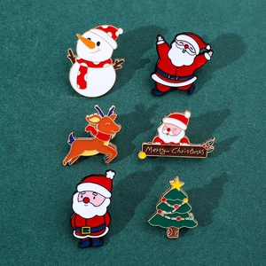 Close-up of set of 6 colorful Christmas enamel pins on a dark green background