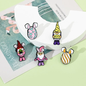 Détail de badges en émail colorés avec des gnomes et des motifs d'œufs de Pâques