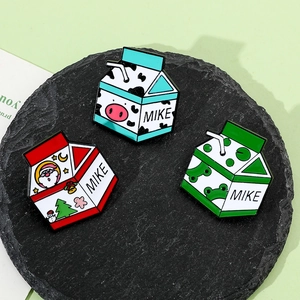 Vue détaillée des pins émaillés en forme de briques de lait en rouge, bleu et vert