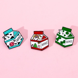 Lot détaillé de trois broches émaillées en forme de briques de lait avec motifs de grenouille
