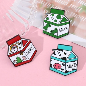 Vue détaillée de pins en émail en forme de briques de lait avec motifs grenouille et Noël