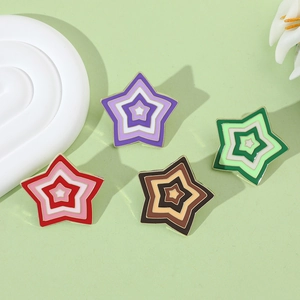 Macro detail of star-shaped enamel pins featuring a layered gradient design and gold metal edges