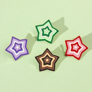 Detailed view of four colorful star-shaped enamel pins with elegant gold metal borders