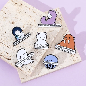 Detailed macro view of enamel pins featuring sea animals and ocean protection slogans