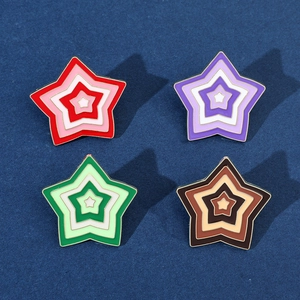 Detail view of four colorful enamel star-shaped brooches in a 2x2 grid layout
