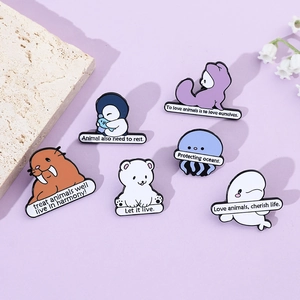 Detail of colorful marine life enamel pins with ocean conservation slogans on lilac backdrop