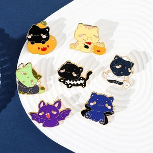 Detailopname van zeven cartoon Halloween katten emaille speldjes op een wit keramisch bordje