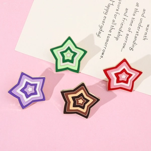 Close-up of four colorful enamel star pins in green, red, purple, and brown tones