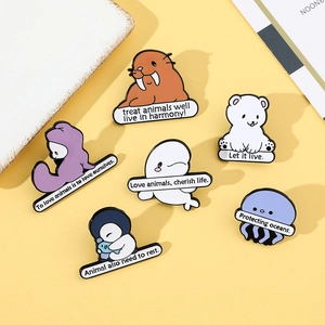 Set of six cartoon enamel ocean animal badges with environmental slogans on yellow background