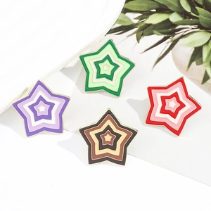 Close-up of colorful star-shaped enamel pins with gradient colors and gold metal edges
