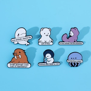Detail of 6 cartoon ocean animal enamel pins with environmental slogans on blue background