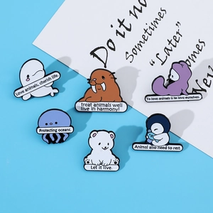 Close-up of ocean animal enamel pins including whale, seal and polar bear designs