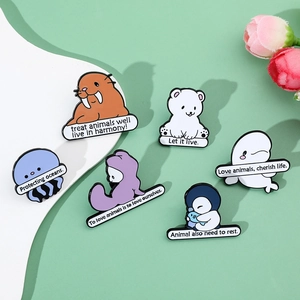 Detail of six marine life enamel pins with ocean conservation slogans on soft background