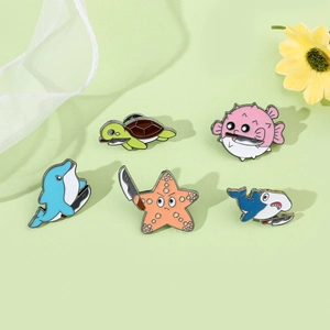 Detailed view of creative enamel ocean pins with sea turtle and shark holding tiny knives