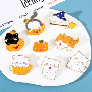Detail van Halloween kat emaille pinnen met pompoenen en spoken op een wit bord