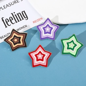 Detail of colorful gradient star enamel brooches with gold metal edging in four colors