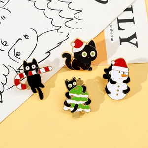 Detail of four Christmas black cat enamel pins with candy cane, hat, tree and snowman