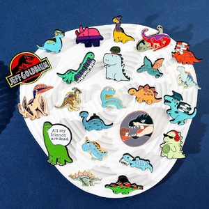 Set di spille in smalto con dinosauri a cartoni animati su uno sfondo blu